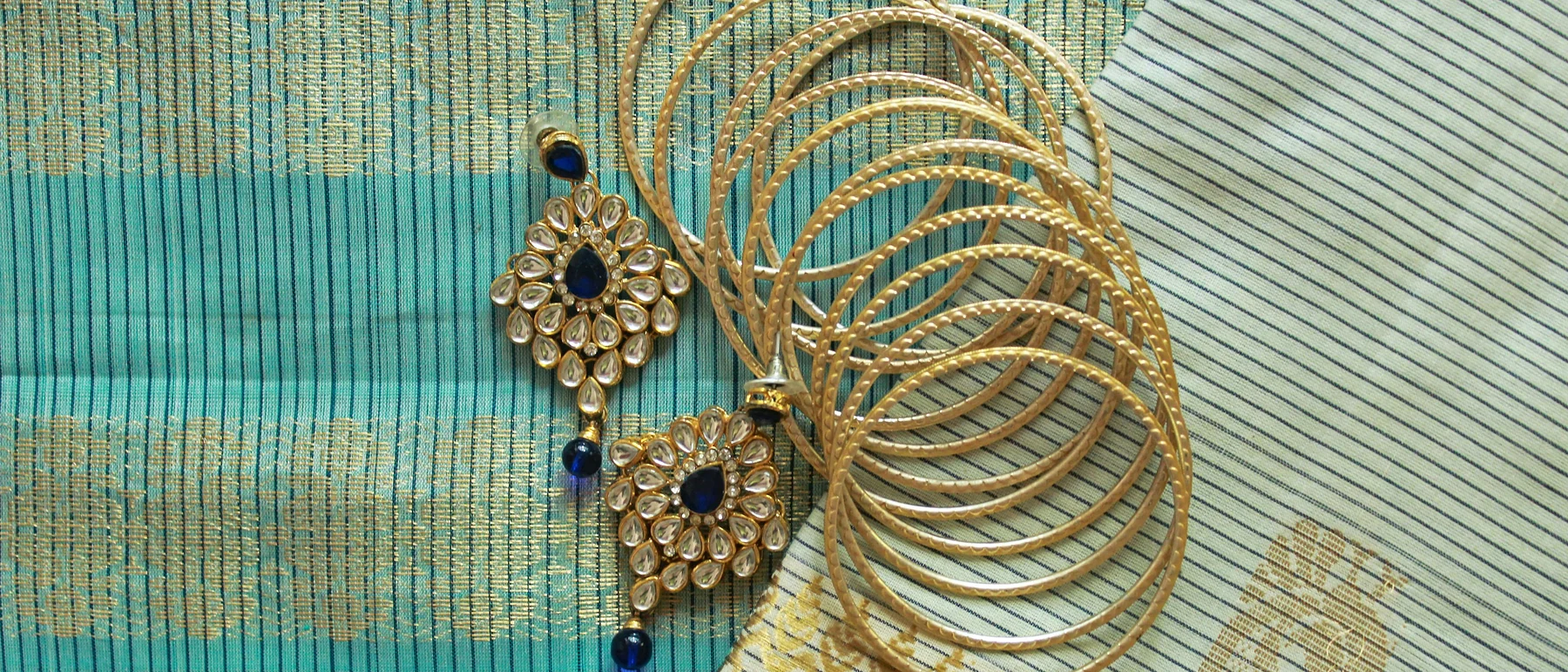 Turquoise zari silk with gold bangles and kundan earrings
