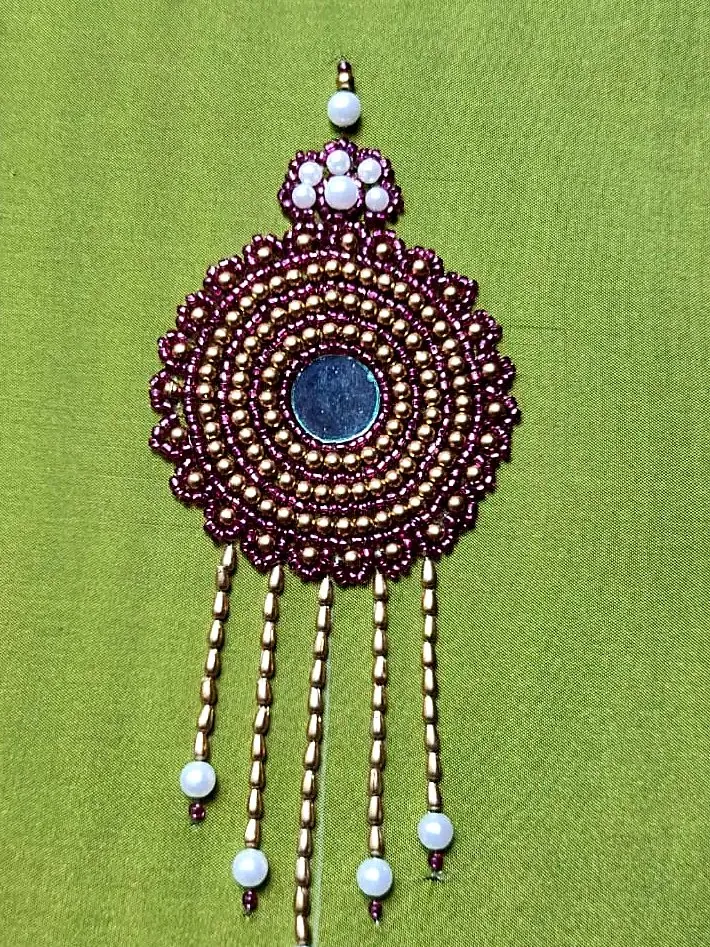 Hand-beaded mirror medallion on green silk
